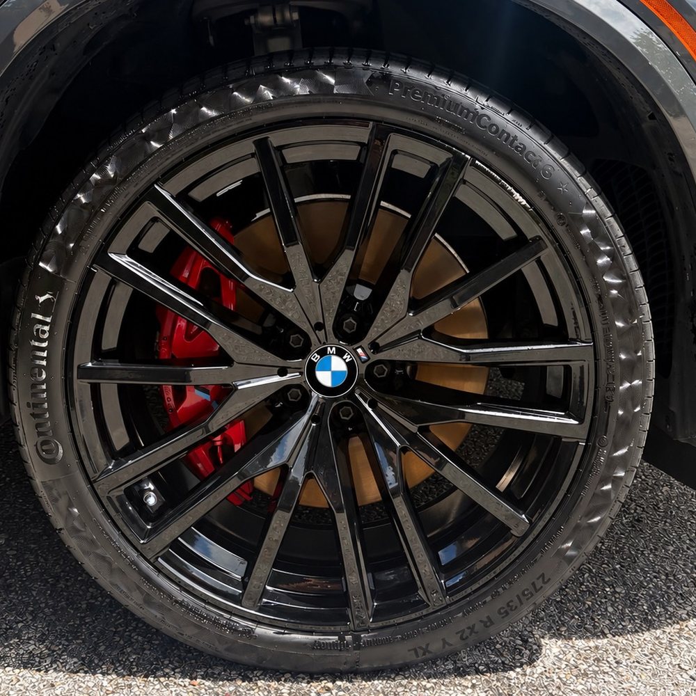 After: the same BMW wheel detailed to a deep gloss with a clean, dressed tire